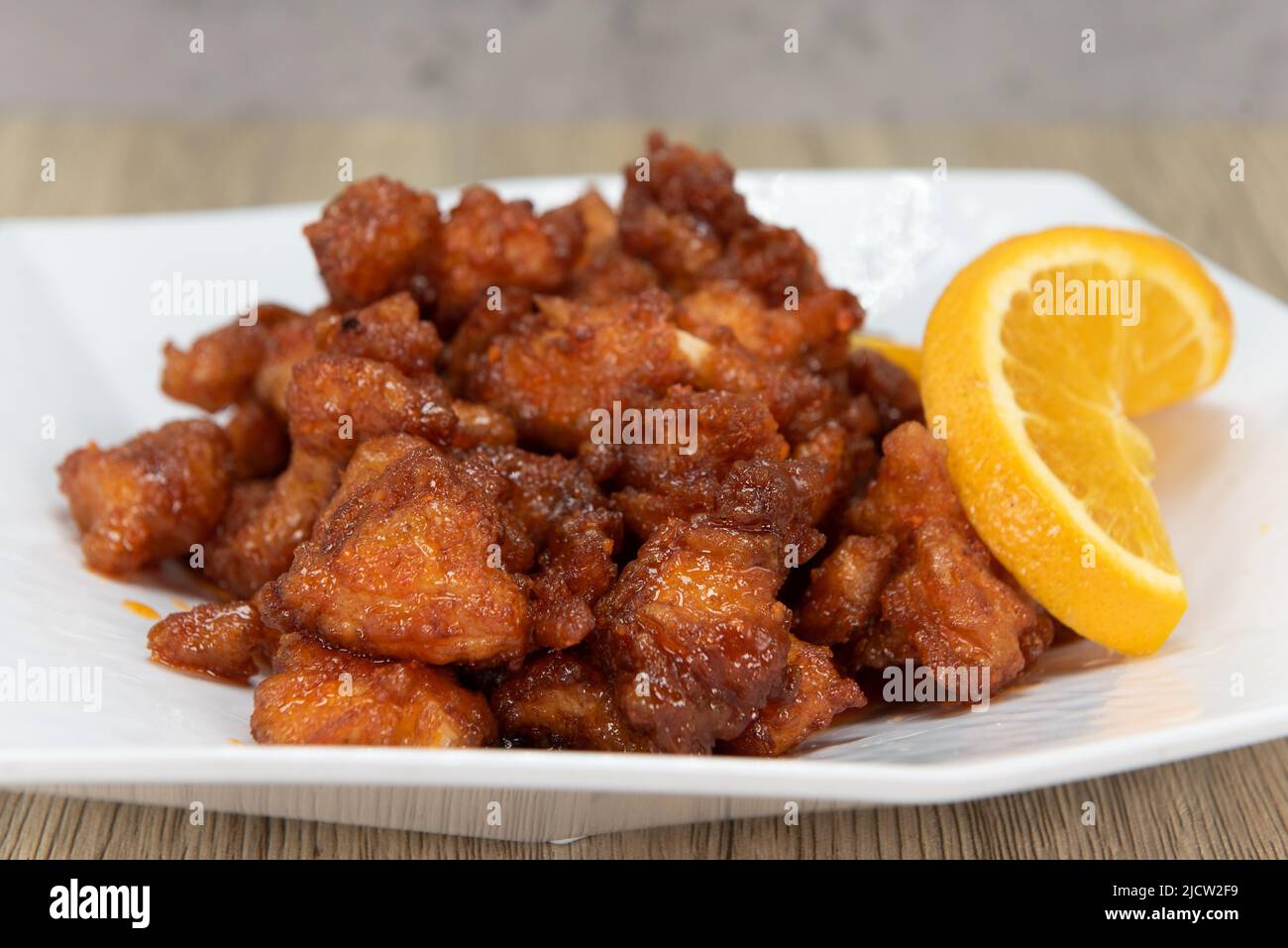 Tangy orange chicken piled high with crispy crunchy pieces and ready to eat. Stock Photo