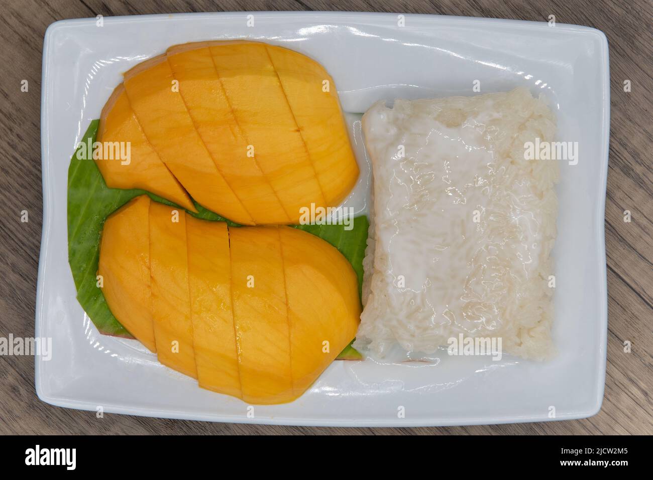 Overhead view of tempting combination plate of sliced mango served with sweet sticky rice. Stock Photo