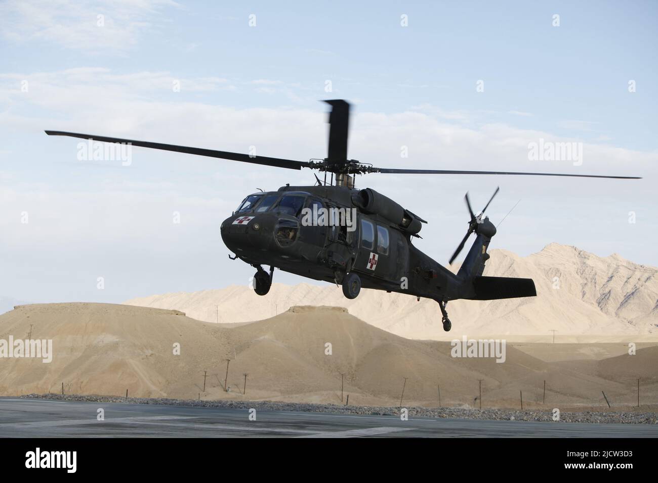 A U.S. Army UH-60 Helicopter prepares to lift off after receiving a wounded local Afghan resident after he sustained a gunshot wound in Kajaki, Afghan Stock Photo