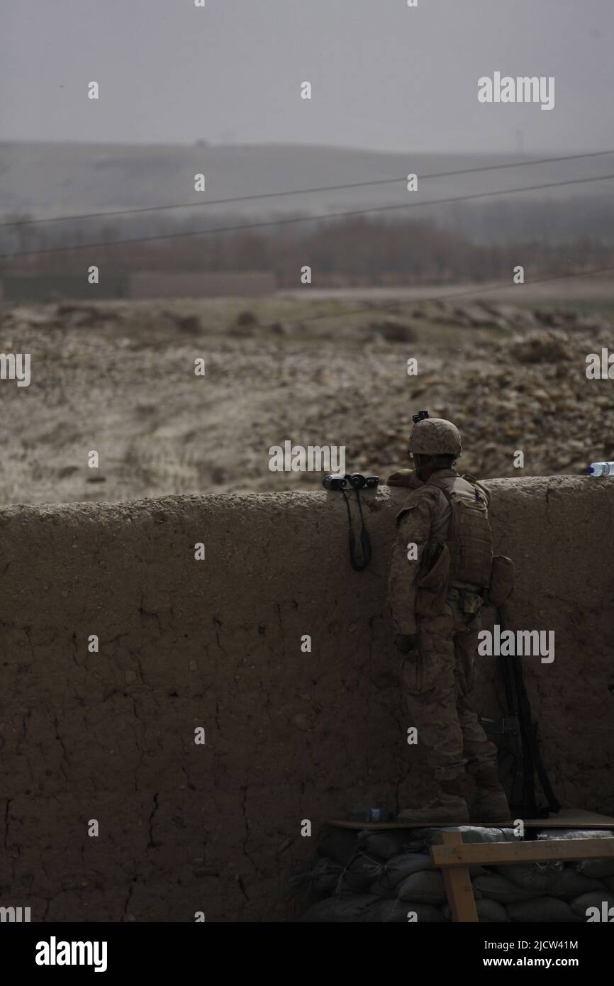 A U.S. Marine with 1st Battalion, 8th Marine Regiment, Regimental Combat Team 6, provides over watch for an outgoing patrol with Afghan Task Force (AT Stock Photo