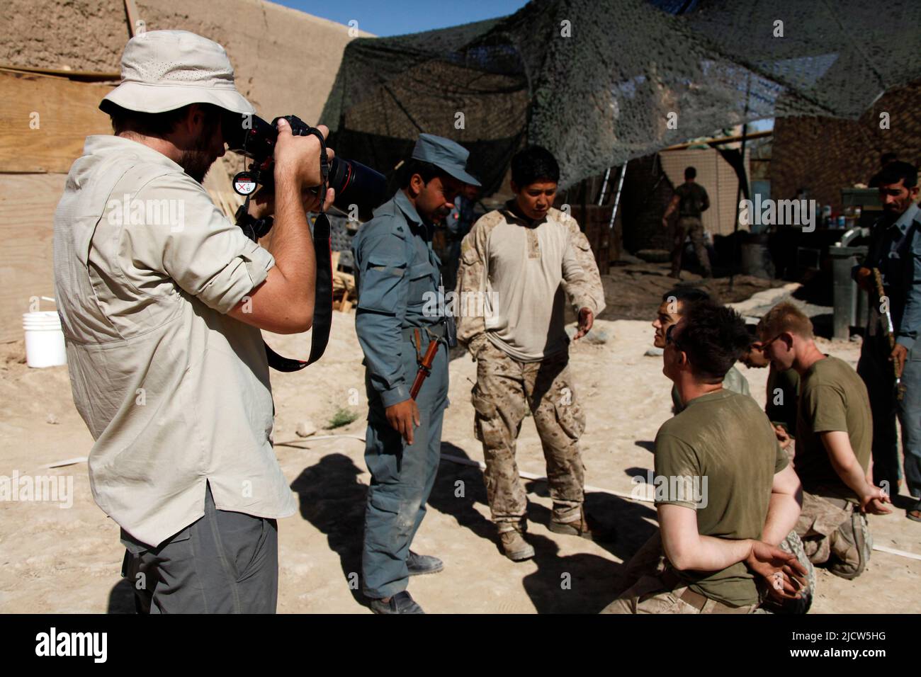 Ben Foley, left, cameraman, with Al Jazeera English News Channel films local Afghan Uniformed Police training as U.S. Marines with Police Advisory Tea Stock Photo