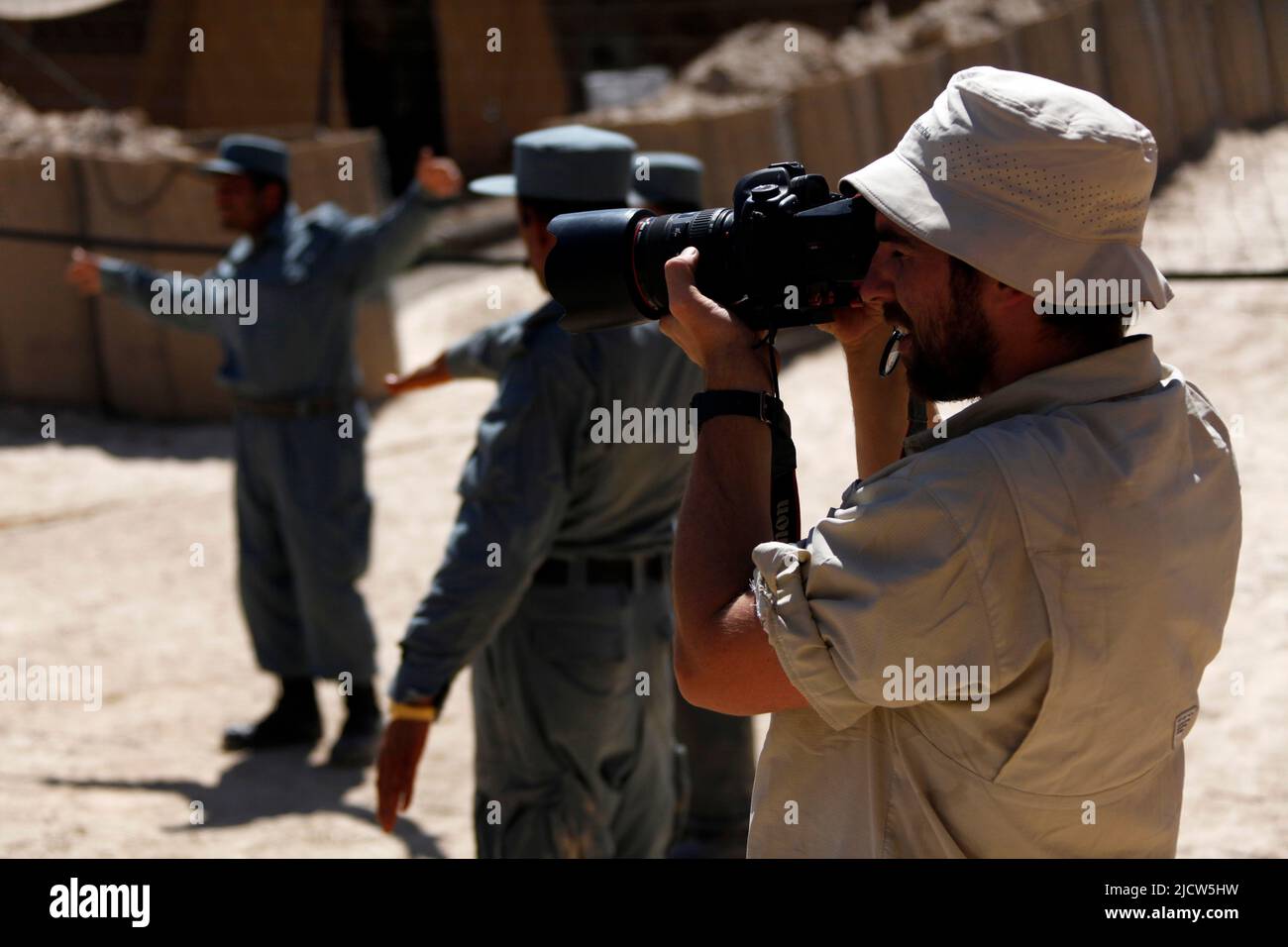Ben Foley, camera man with Al Jazeera English News Channel films local Afghan Uniformed Police during a physical training session alongside U.S. Marin Stock Photo
