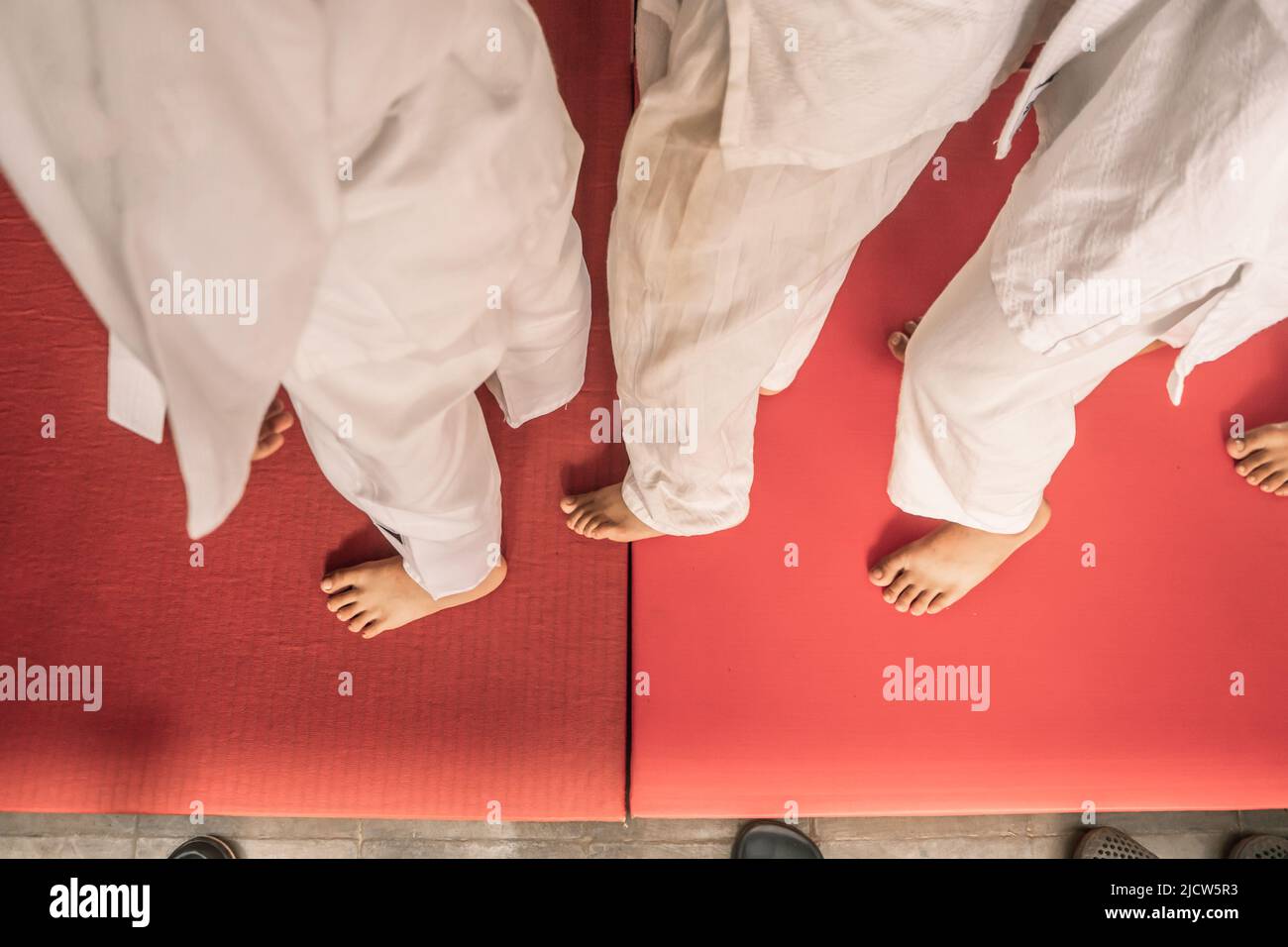 Top view at the feet of teenage judo fighters in their white uniform on