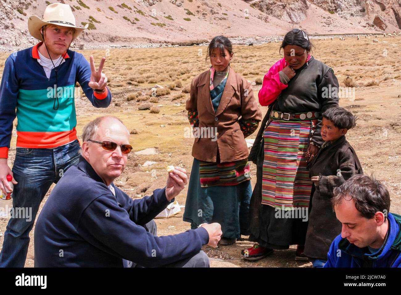 As we drove over the Nyenchen Tanglha Mountains we stopped for lunch and and shared some of our food with the Tibetan nomadic family that we met. Stock Photo