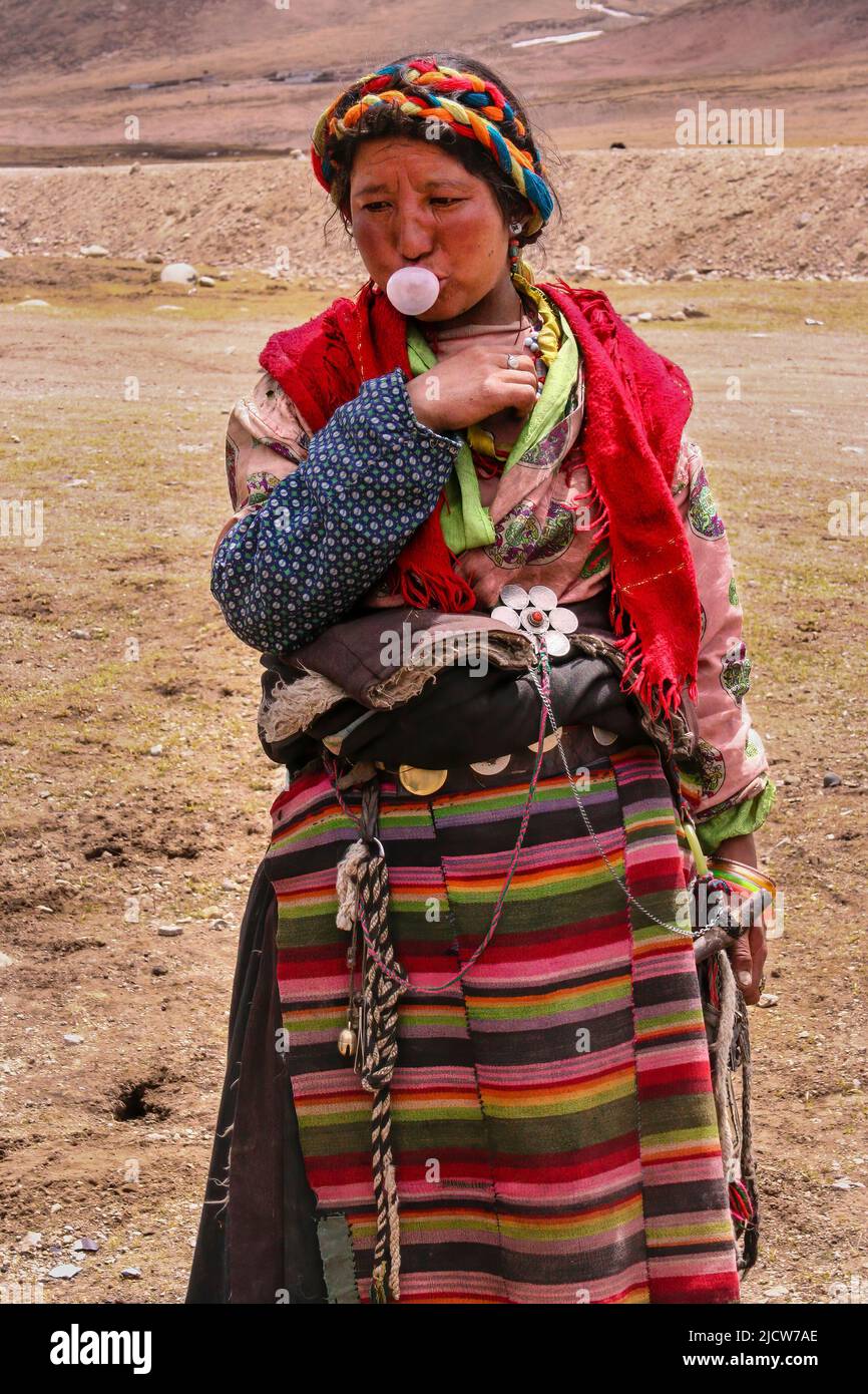 This Tibetan nomadic woman knew what to do with the bubble gum we gave her as we stopped for lunch . Stock Photo