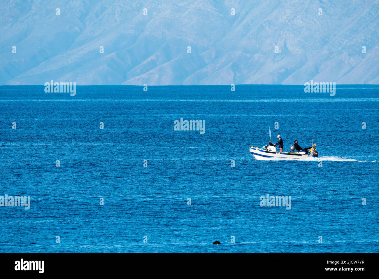 recreational boat on the sea or ocean with men onboard for leisure activity in Cape Town, South Africa Stock Photo