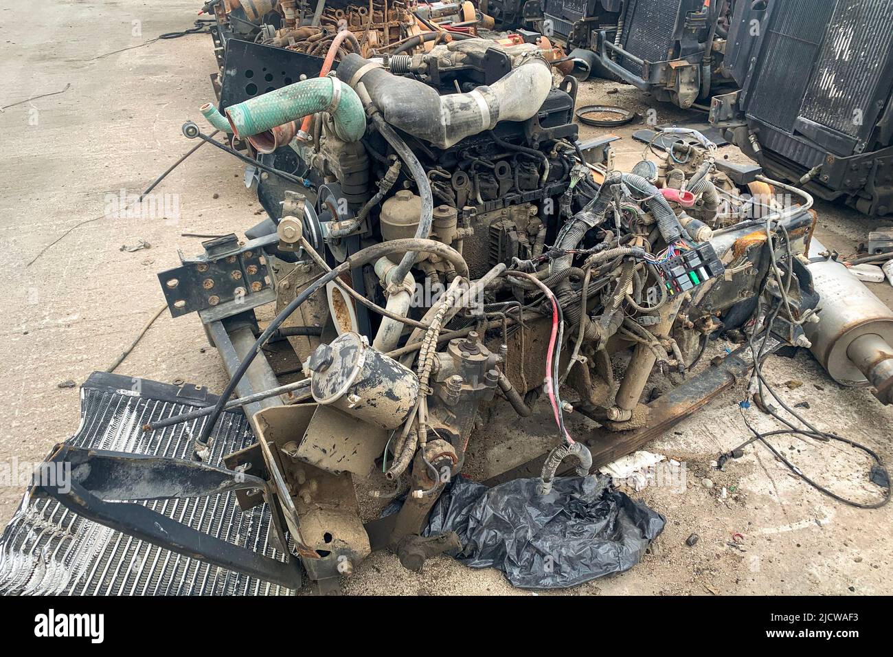 Closeup of internal combustion engine removed from a car and resting on the ground in a automotive wrecking Stock Photo