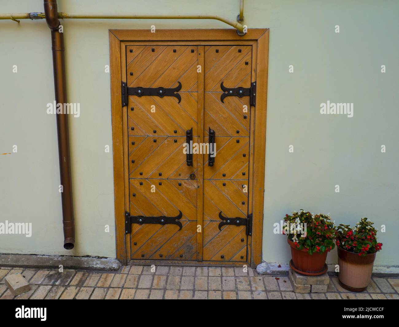 Ancient wooden door with iron rivets at wall of white building Stock ...