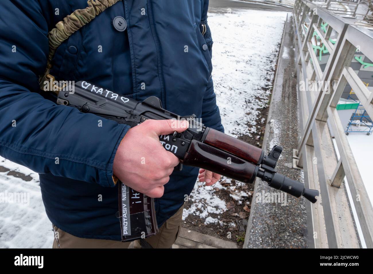KYIV, UKRAINE 01 March. A member of the Territorial defense forces stands guard with a Kalashnikov rifle bearing writing with the name of his girlfriend 'Katia' in Protasiv neighbourhood as Russia's invasion of Ukraine continues on 01 March 2022 in Kiev, Ukraine. World War II. Stock Photo