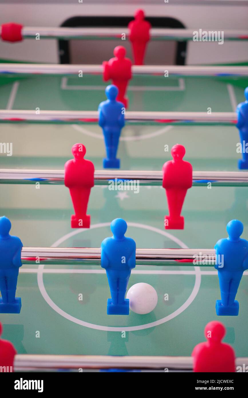 Close up of foosball Table Soccer Game match figures. Football Kicker Game with blue and red figurines. Stock Photo