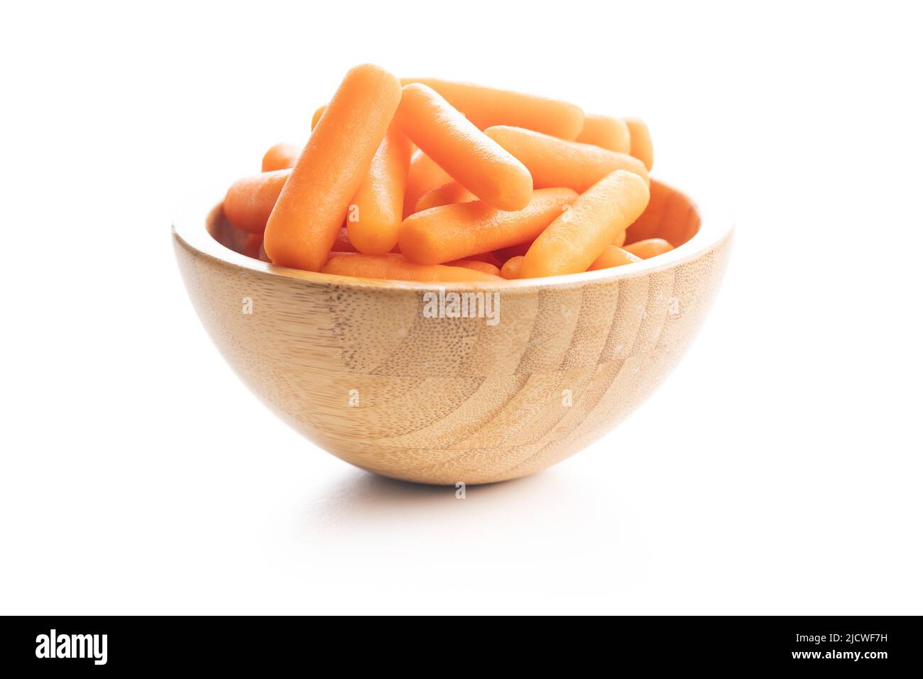 Baby carrot vegetable in bowl. Mini orange carrots isolated on white background. Stock Photo