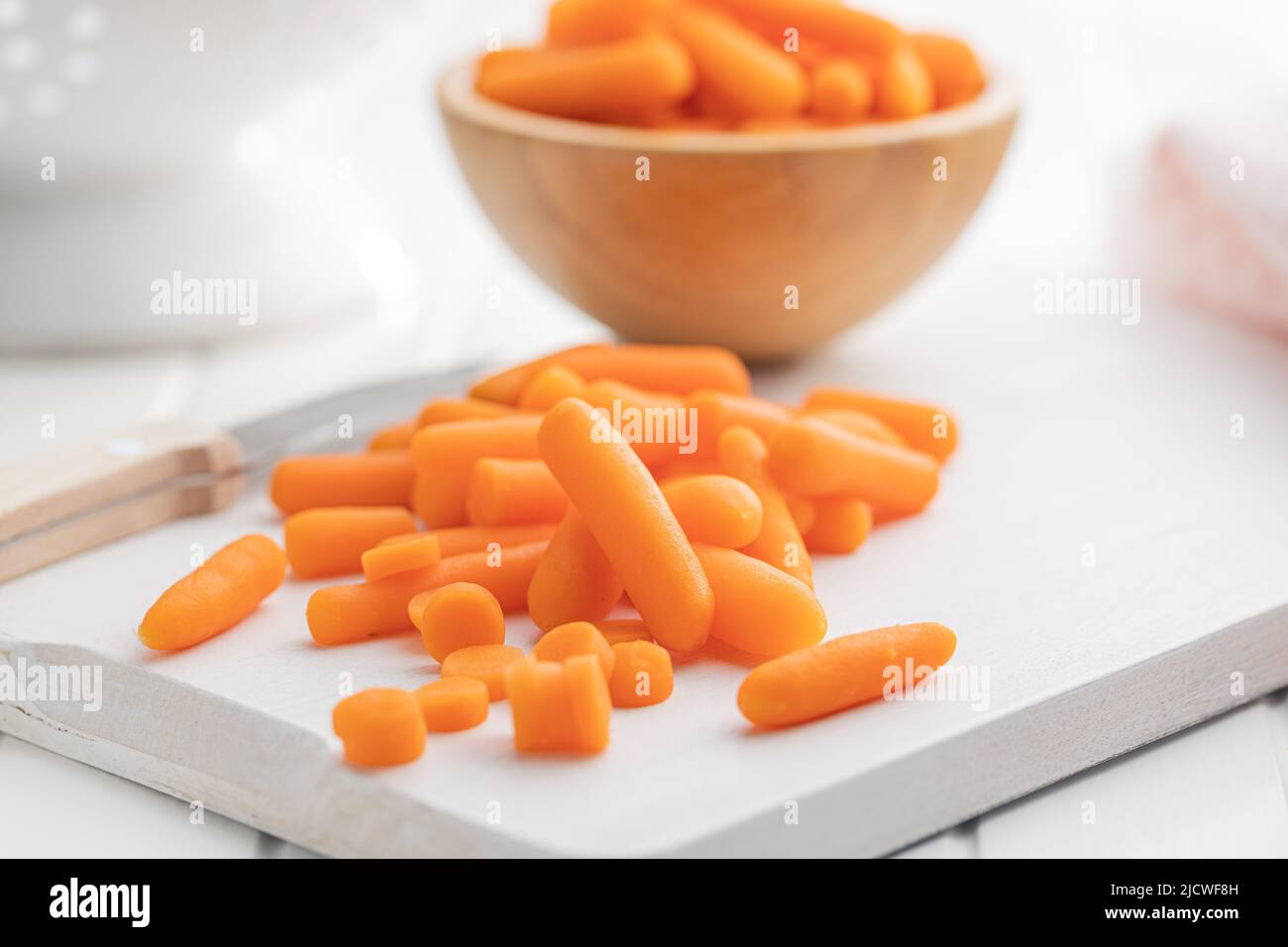 Baby carrot vegetable. Mini orange carrots on white table. Stock Photo