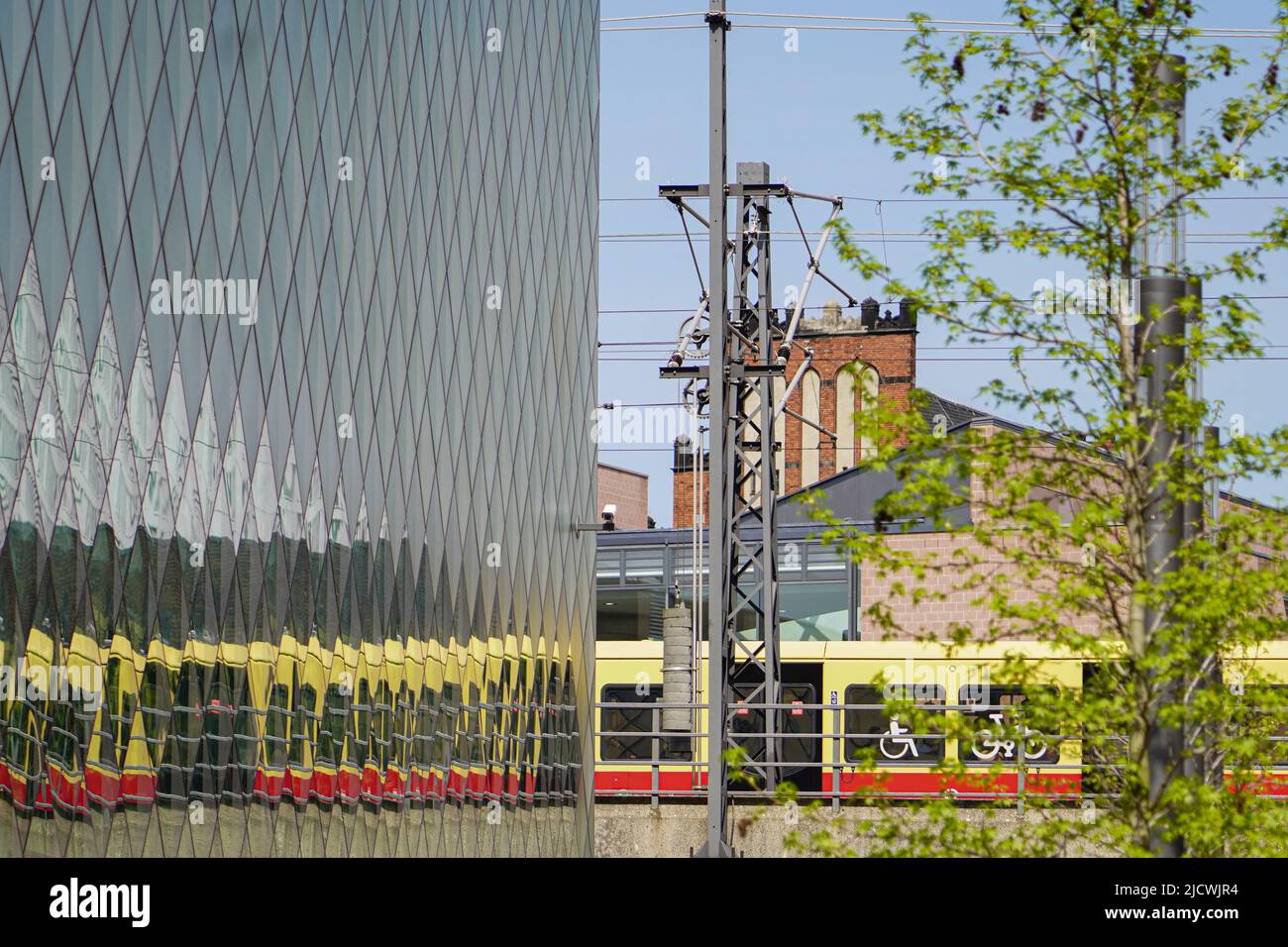 Reflection of a moving Berlin suburban train in the glass facade of the Futurium Berlin, Germany, 29.4.22 Stock Photo