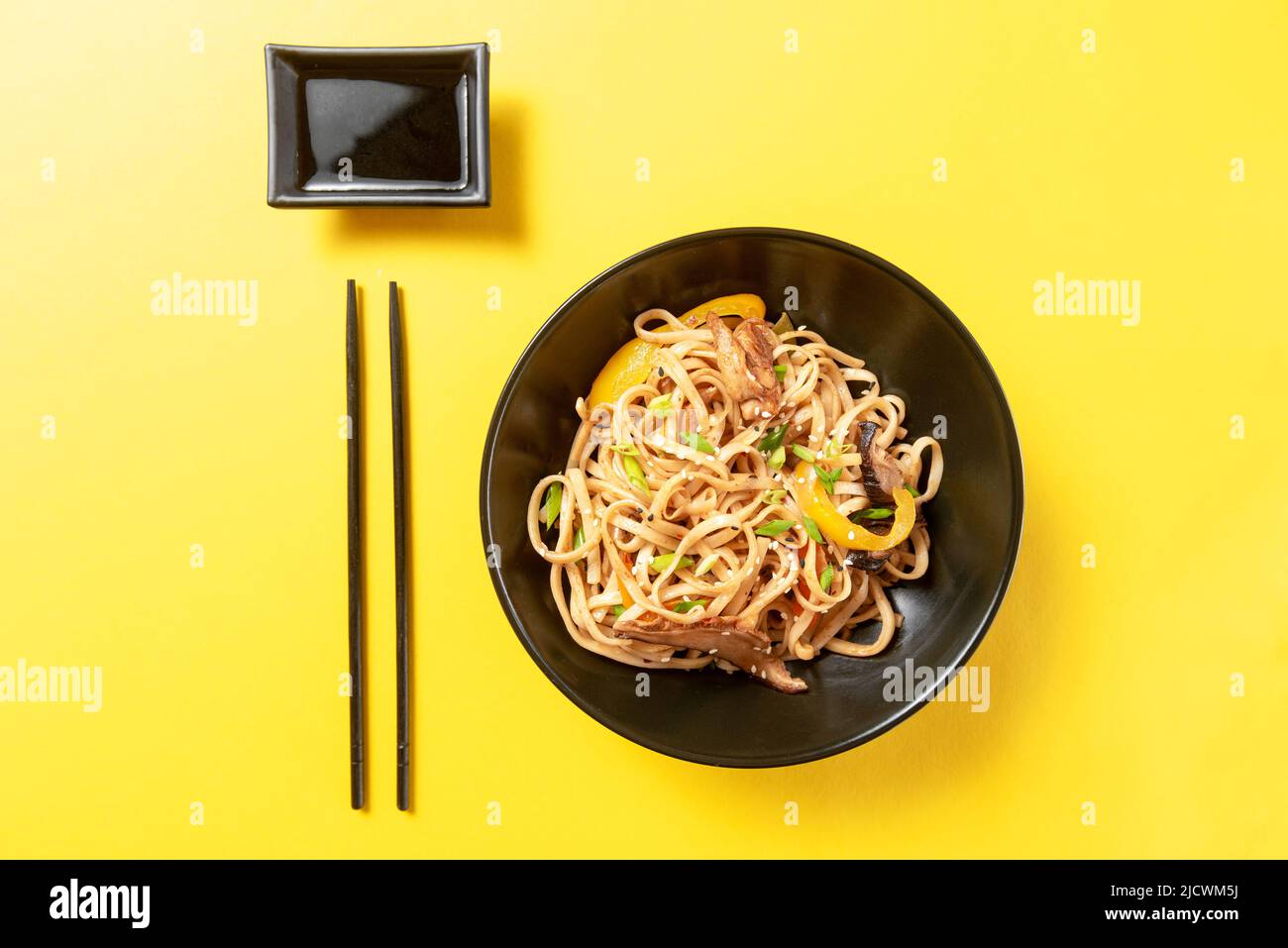 Asian udon noodles with sauce on yellow background Stock Photo