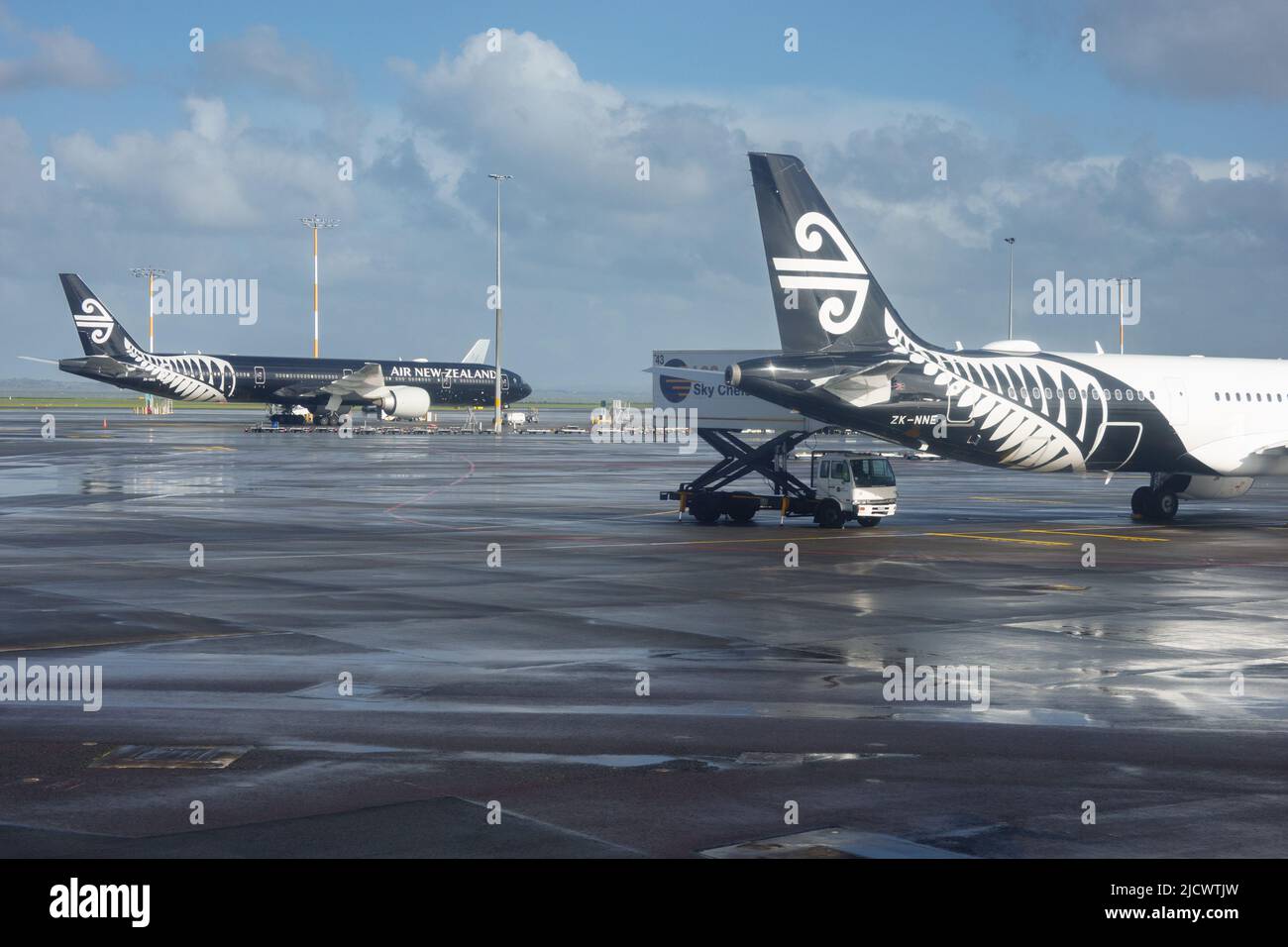 Auckland New Zealand - June 13 2022: White and black Air New zealand planes parked on tarmac. at Auckland Airport after rain. Stock Photo