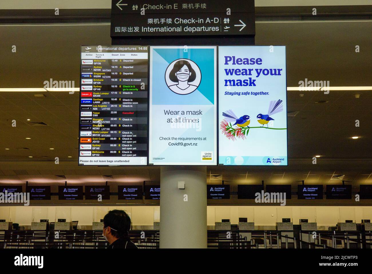 Auckland New Zealand - June 13 2022: Flight information display service board in airport providing flight arrivals and departure times with covid mess Stock Photo