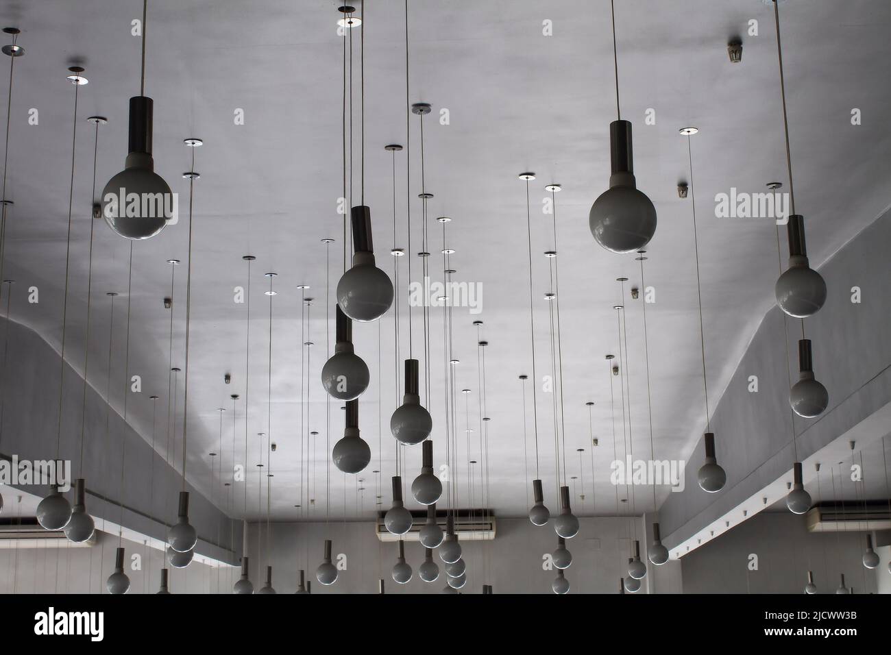 Round ceiling lamps on wires at studio Stock Photo