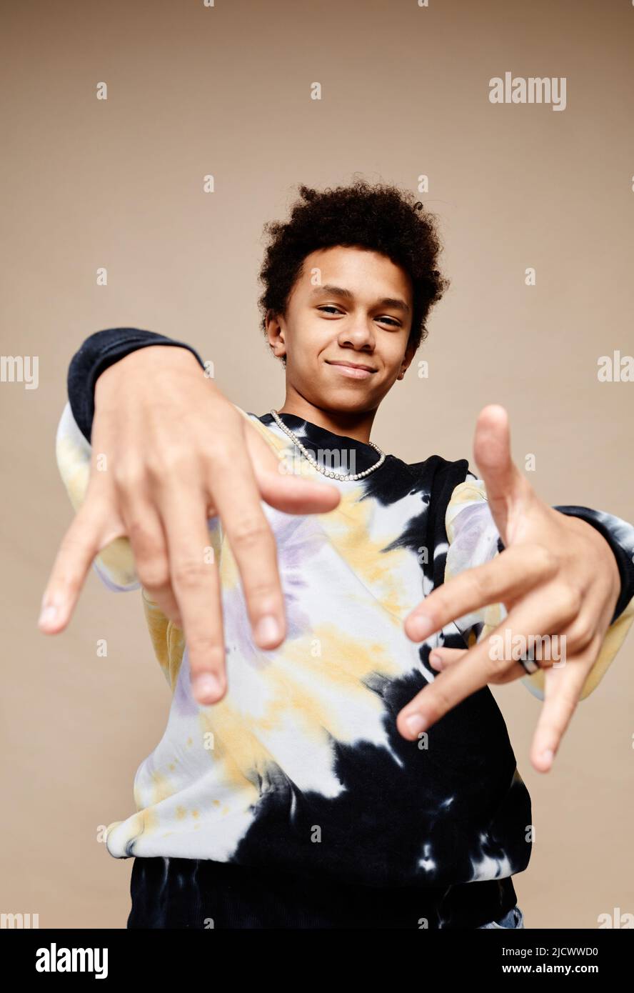 Vertical portrait of black teenage boy wearing tie dye shirt and