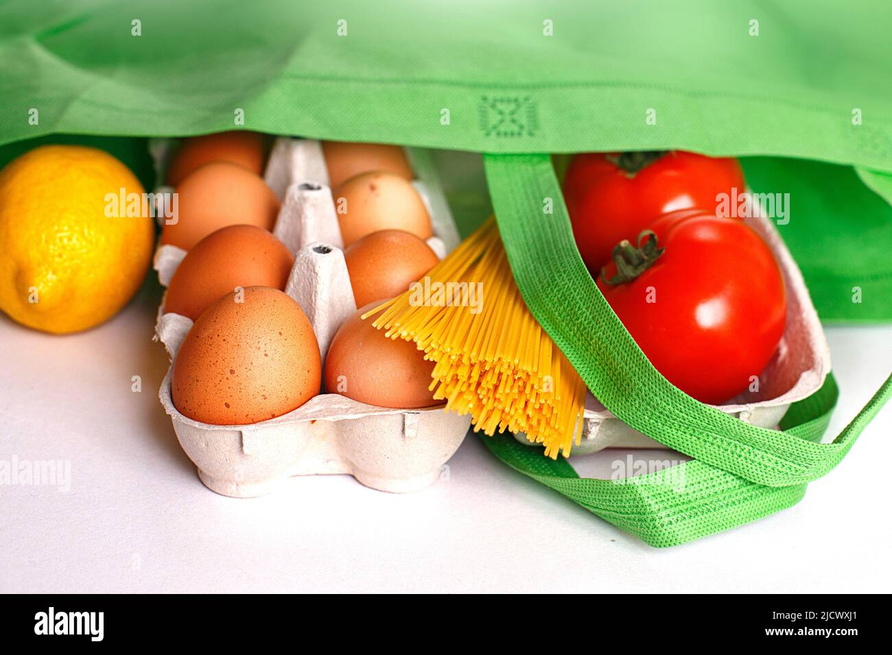 Full green bag of healthy food on a white background. Top view. fruit, vegetable, eggs online shop. your text. food delivery Stock Photo