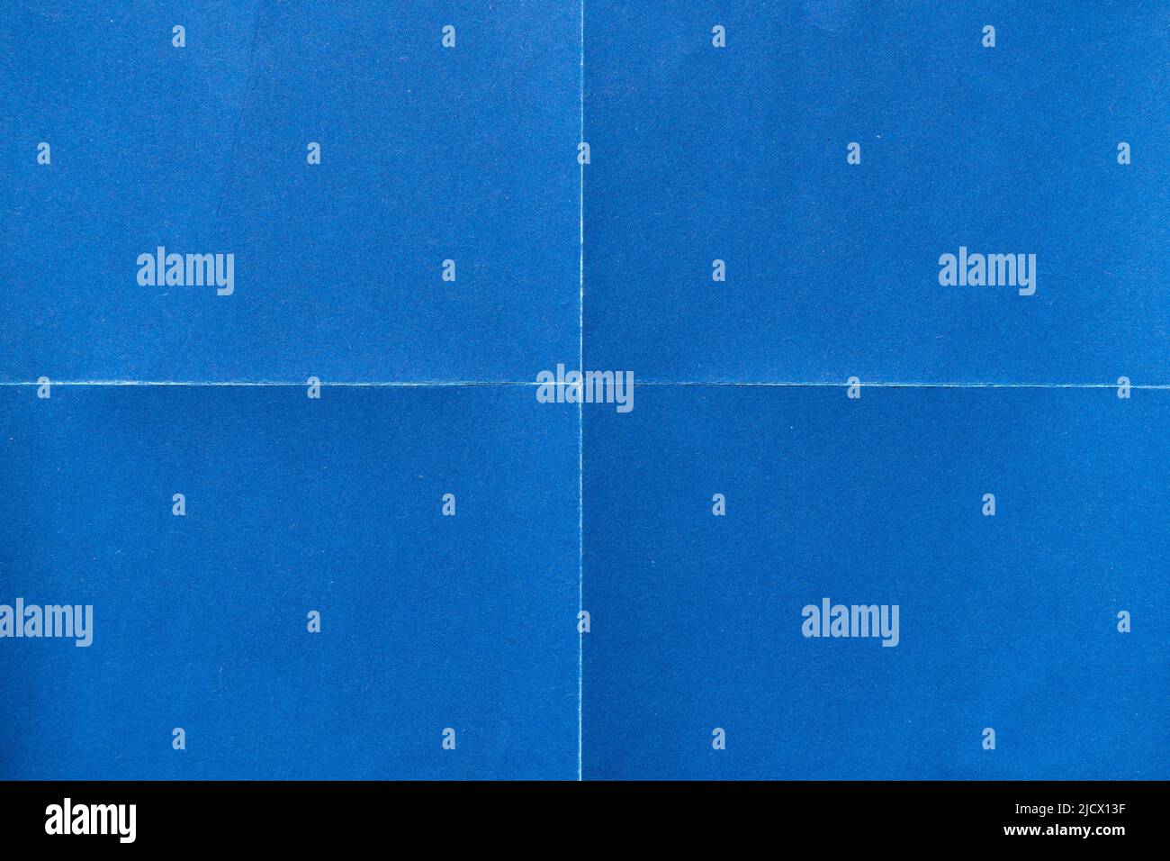 Blue paper background with creases that separates paper into four parts Stock Photo