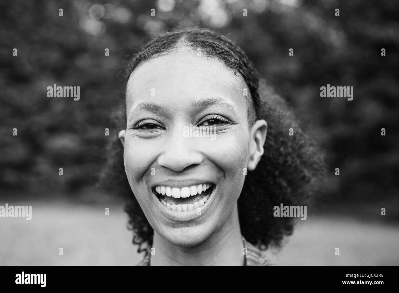 Young african girl smiling on camera outdoor - Focus on face - Black and white editing Stock Photo