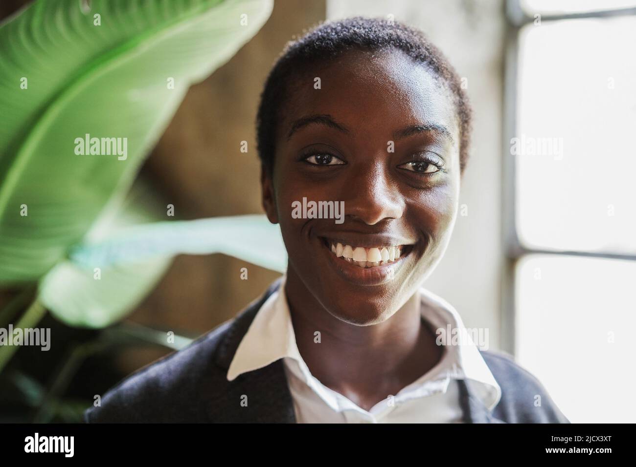 Happy african business girl smiling on camera inside modern office - Focus on face Stock Photo