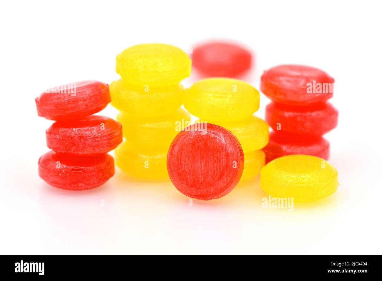Pile of red and yelow lozenges candy on white background. Stock Photo