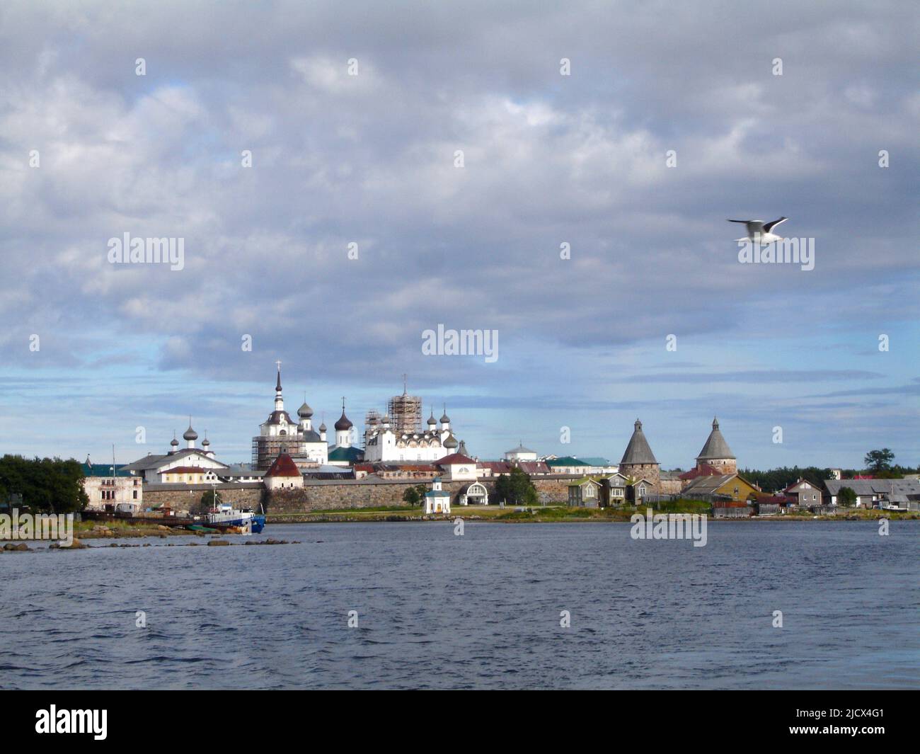 View of the White Sea and the Spaso-Preobrazhensky Solovetsky Monastery on a summer day. A seagull in the sky. Solovetsky Islands. Arkhangelsk region. Stock Photo