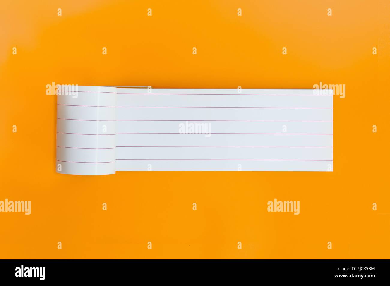 Long empty notebook for text on orange background. Open planner sheet, reminder. Copy space Stock Photo