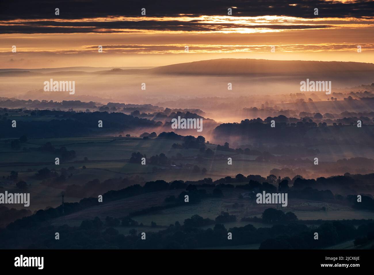 Morning sunbeams and early morning fog cover the Cheshire Plain at sunrise, from Bosley Cloud, Cheshire, England, United Kingdom, Europe Stock Photo