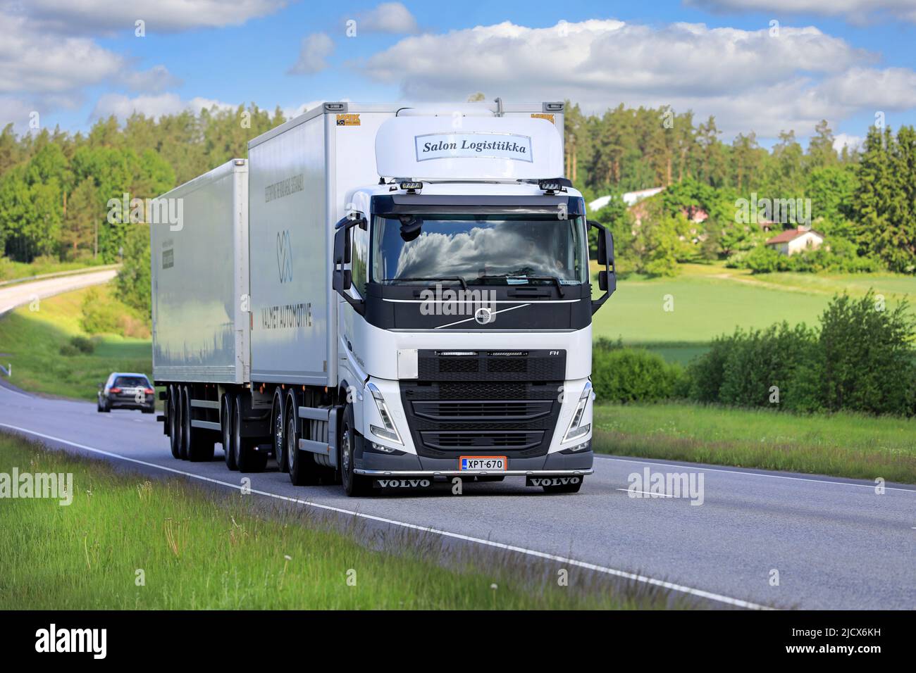 New, white Volvo FH truck Salon Logistiikka Ky pulls trailer along highway 52 on a day of summer. Salo, Finland. June 9, 2022. Stock Photo