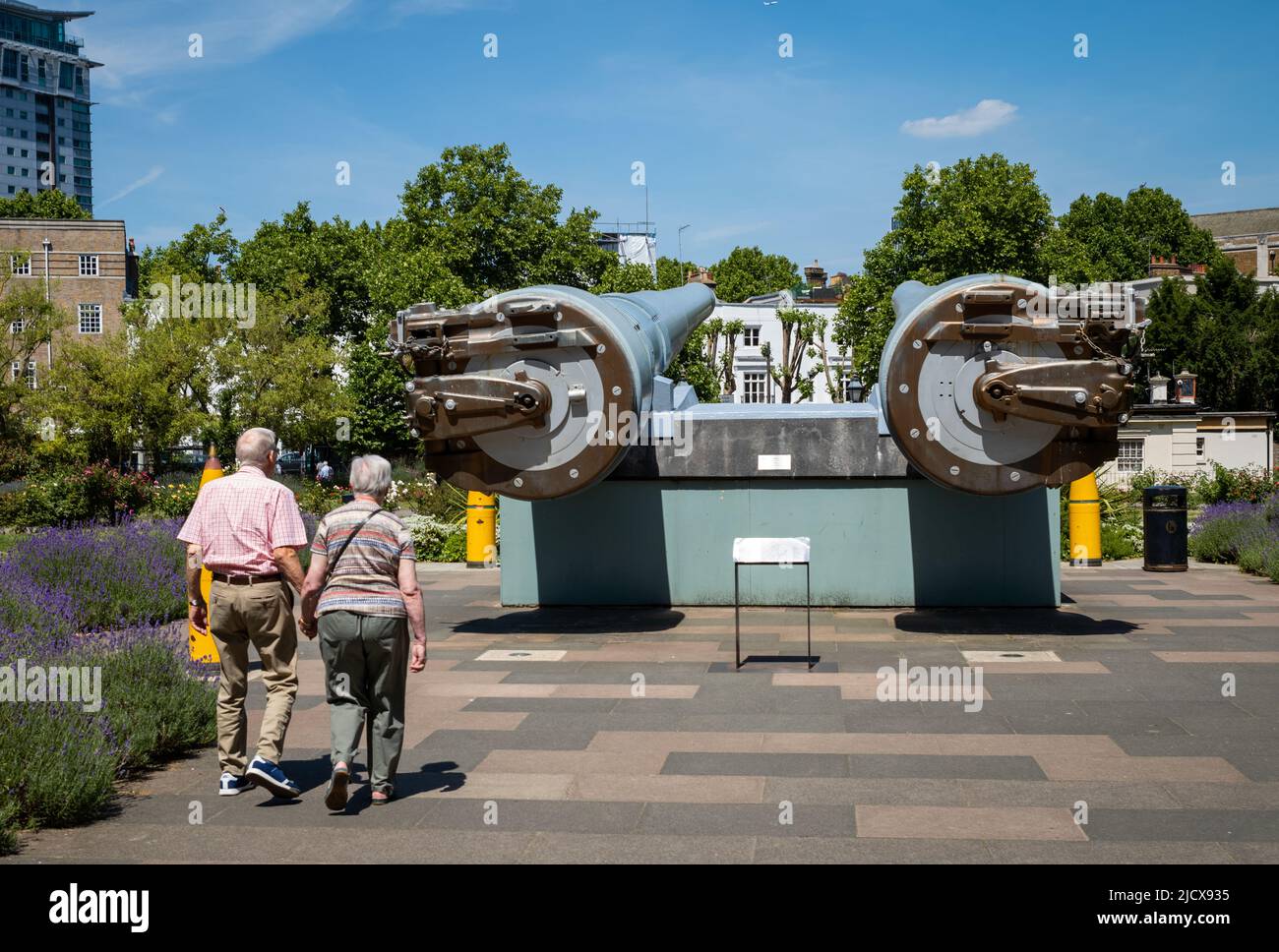 An elderly couple walk hand-in-hand at the front of the Imperial War Museum (IWM) in London. Stock Photo