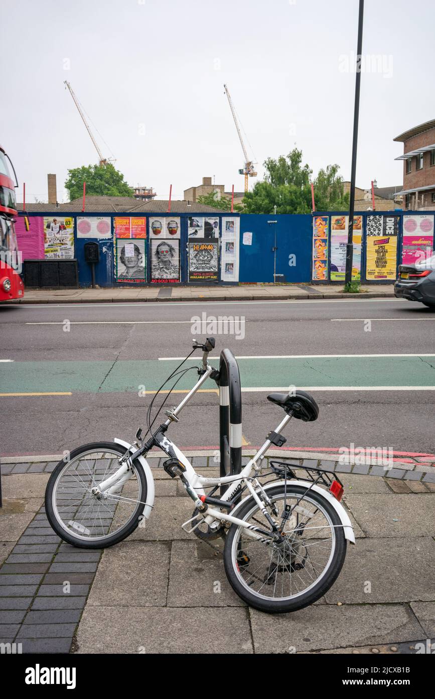 Street view with ladies bicycle leaning against bollard in the street
