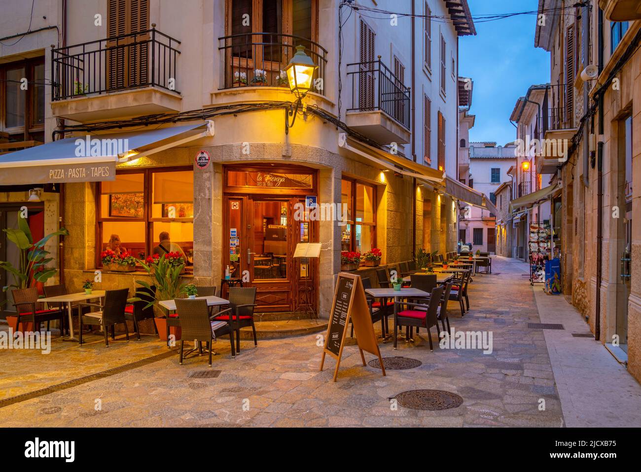 View of bar in narrow street in the old town of Pollenca at dusk, Pollenca, Majorca, Balearic Islands, Spain, Mediterranean, Europe Stock Photo