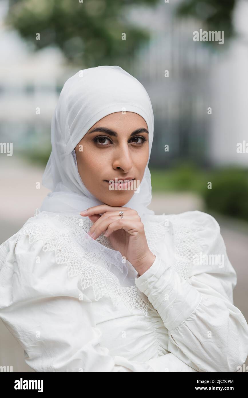 portrait of muslim bride in hijab with diamond ring on finger looking