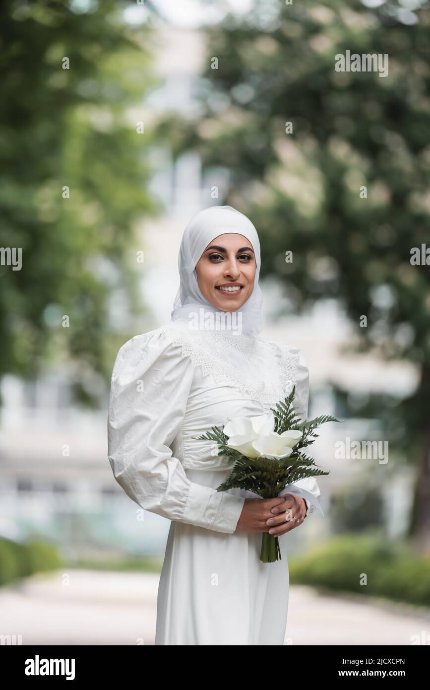smiling muslim bride with diamond ring on finger holding wedding