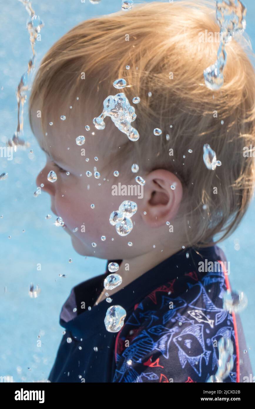 Little boy, 18 months old, playing in a splashpark in Stokes Bay
