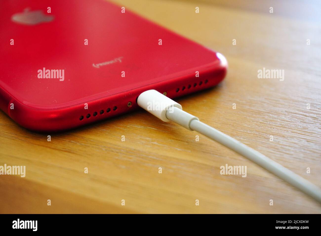 30 April 2021 Eskisehir Turkey. Red iphone 11 being charged by powerbank on wooden table Stock Photo