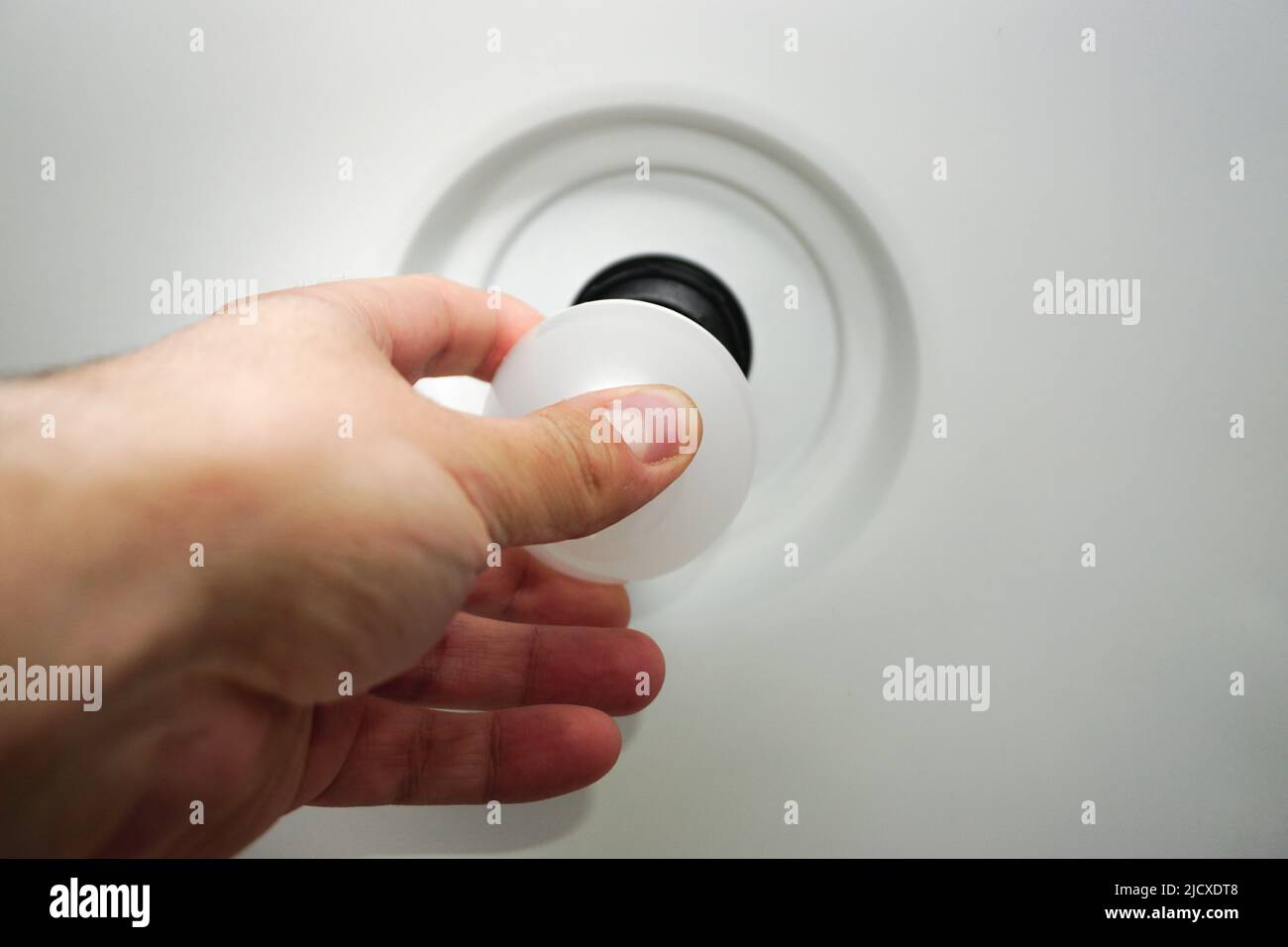 Man change bulb in the ceilling lamp close up view Stock Photo