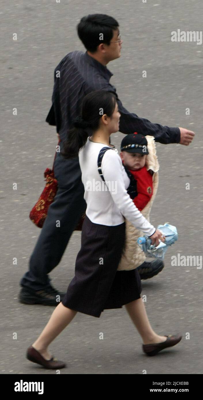 North Korean family walking on front of Koryo hotel in Pyong yang, central of North Korea on Oct 3, 2007. Stock Photo
