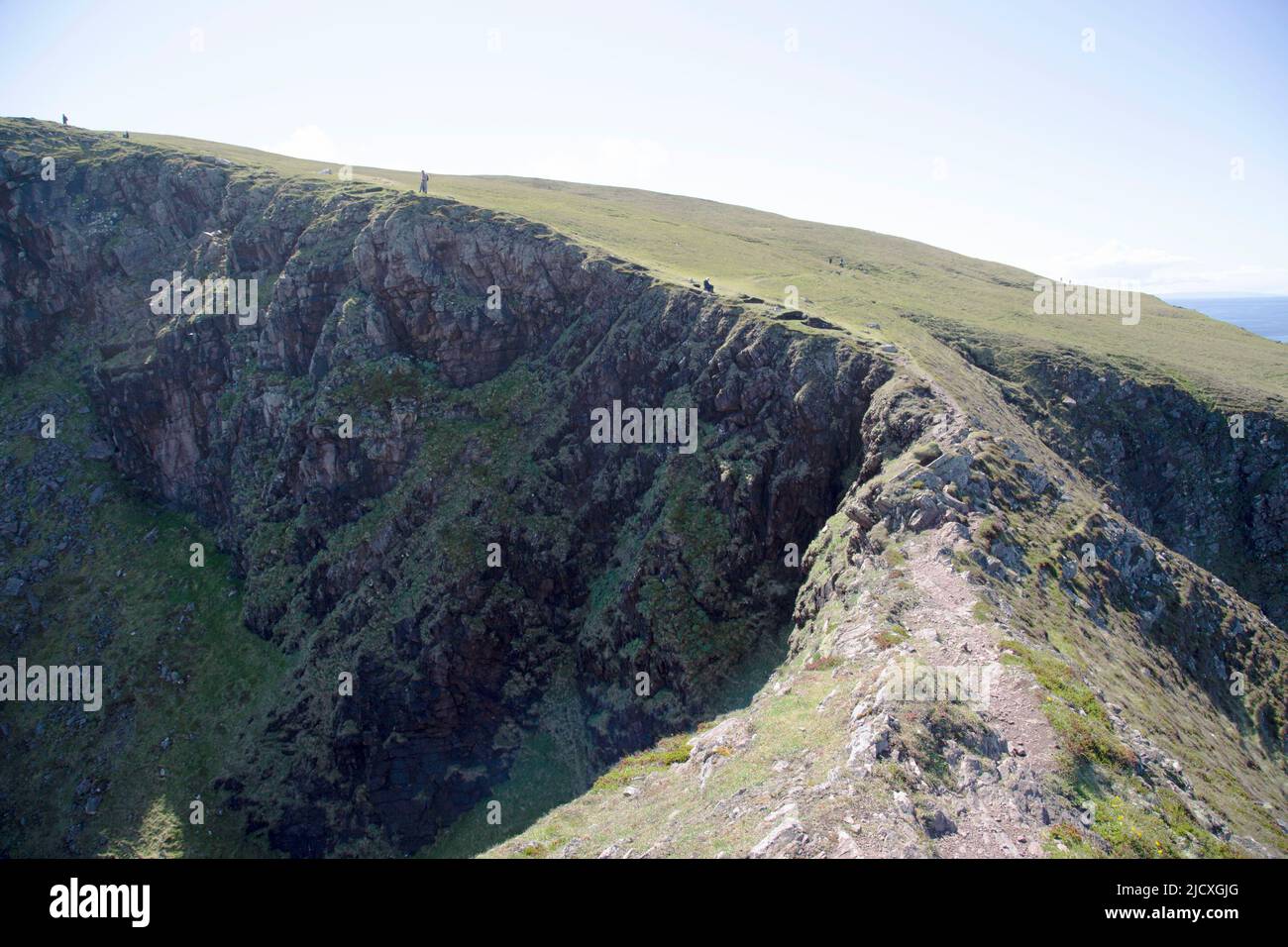 Knife edge path and people standing on the cliff edge, Stoer Headland, Point of Stoer, Assynt, Scotland Stock Photo