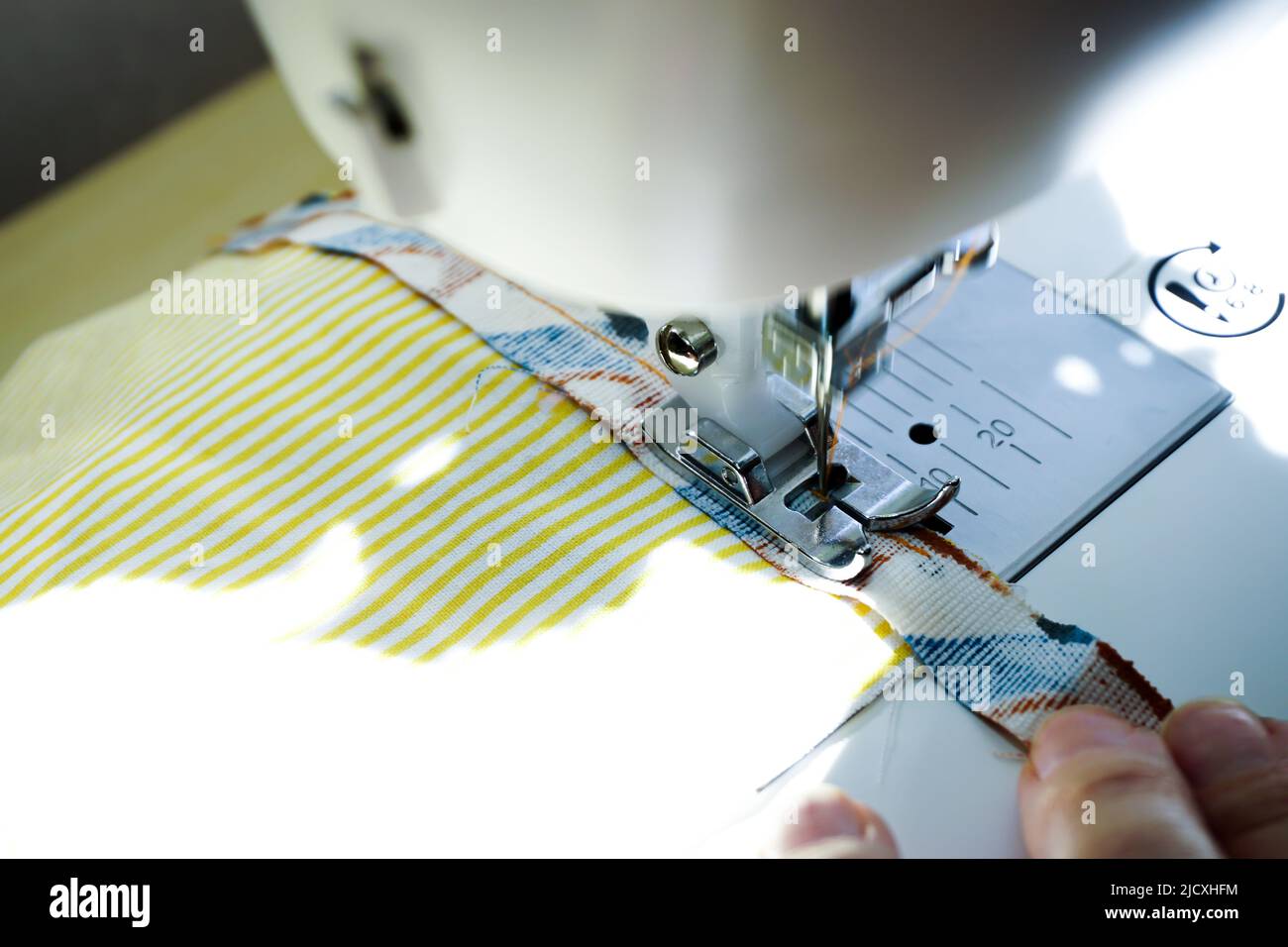 Sewing machine needle bobbin and stitch settings details close up view