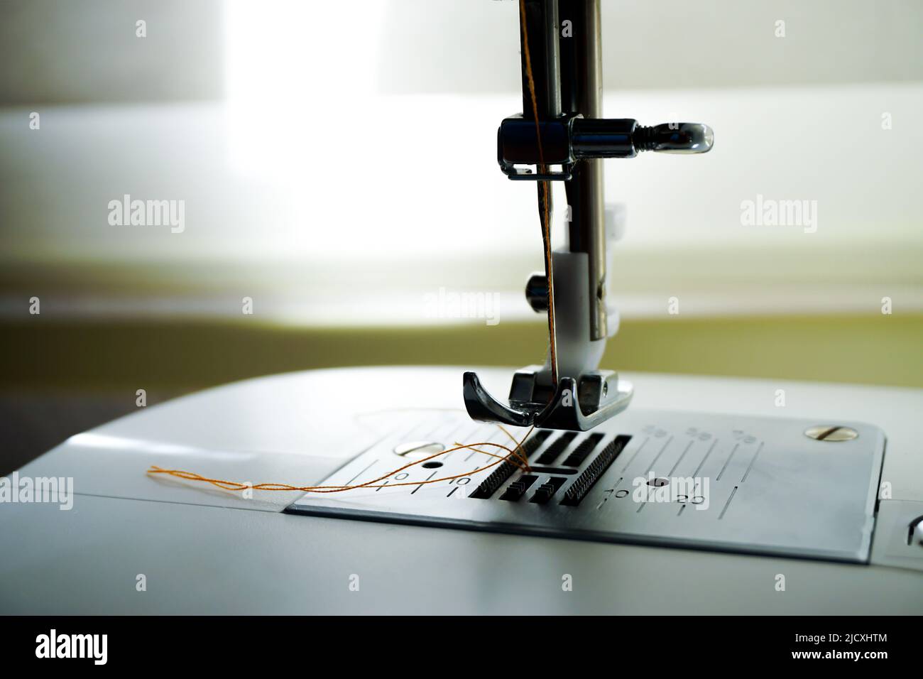 Sewing machine needle bobbin and stitch settings details close up view