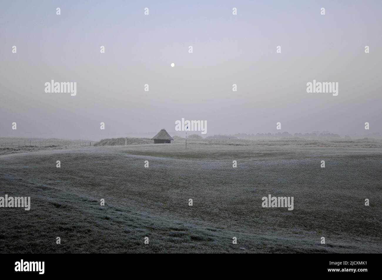 Princes Golf Club - view over 5th Green on Shore Golf Course on a Frosty morning at sunrise with The Moon, Sandwich, Kent, England Stock Photo