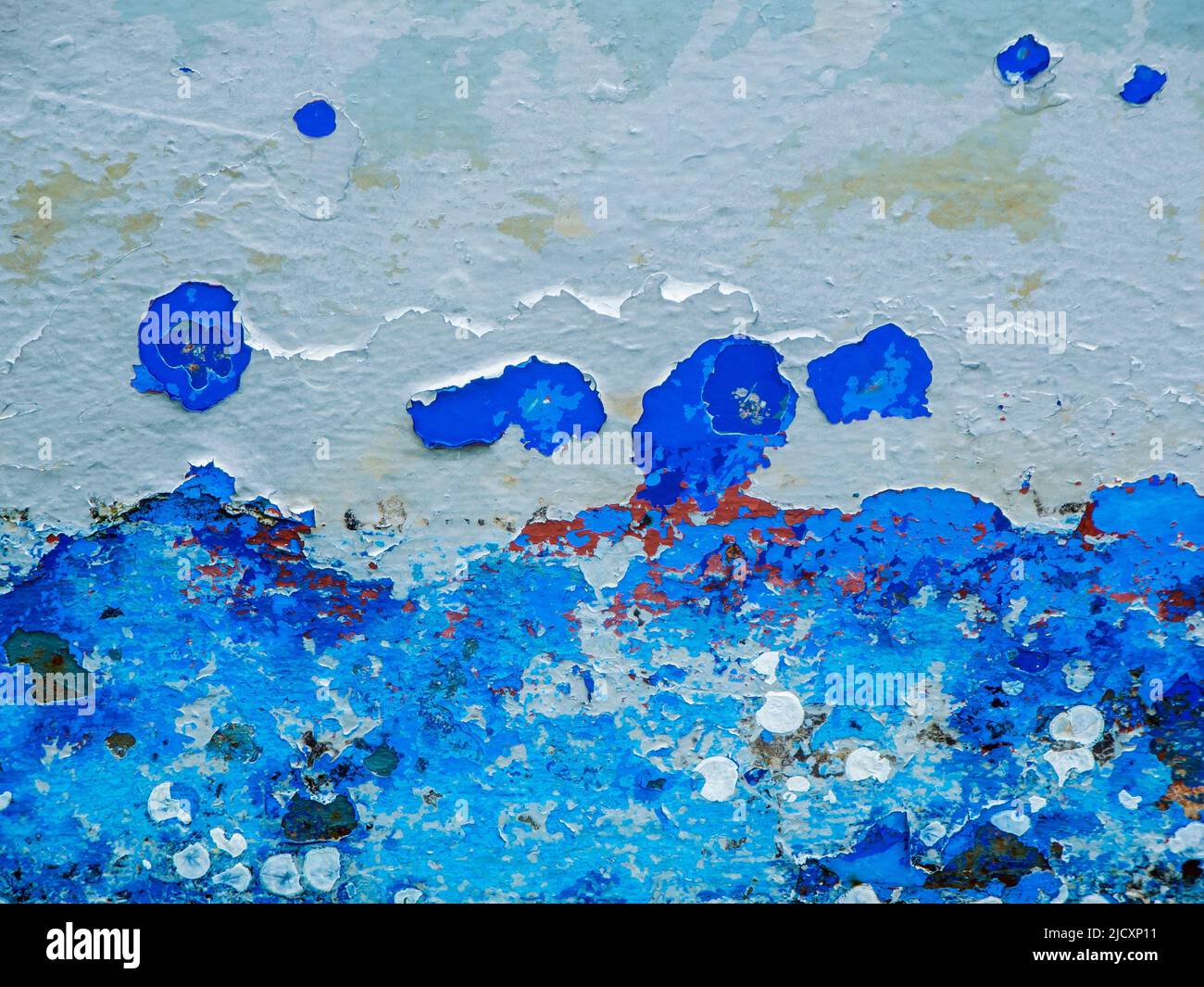 Format-filling view of a metal wall with chipped blue paint in various shades of blue. Stock Photo