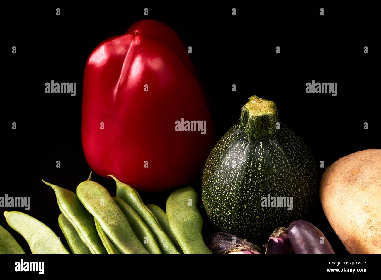 Variety of juicy vegetables on a black background. Healthy food. Vegetarian food Stock Photo