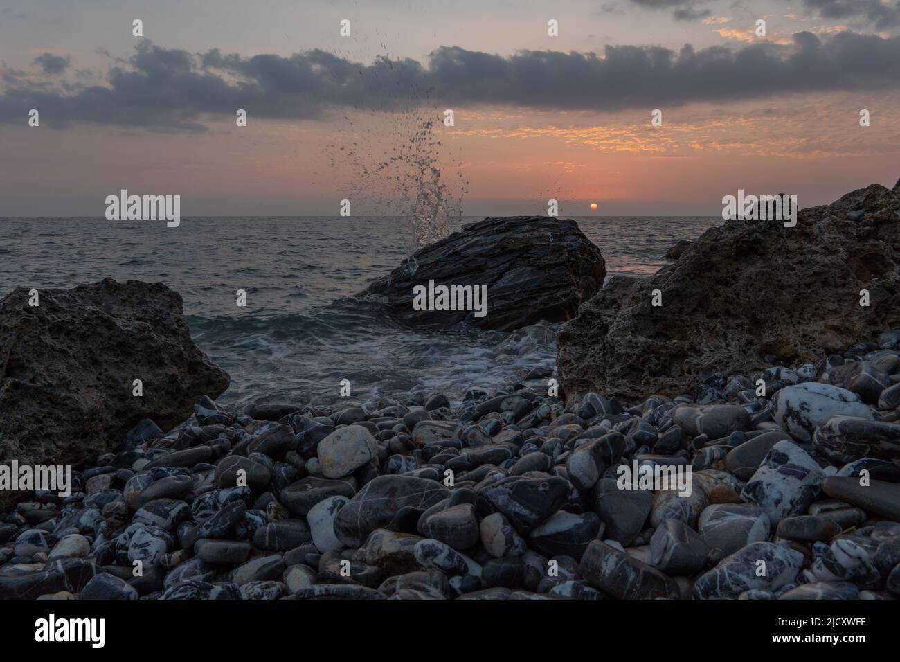 Beautiful evening atmosphere on a rocky beach in Italy Stock Photo