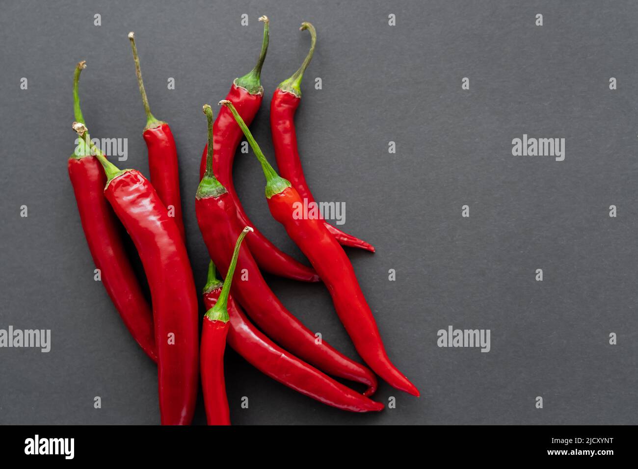 Top view of ripe chili peppers on black background Stock Photo - Alamy