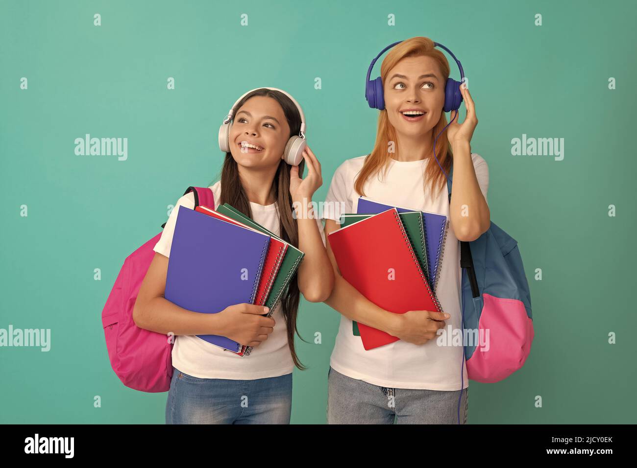 inspired school pupil and student in headphones holding workbooks and ...