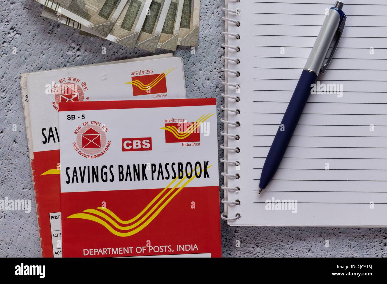 Birbhum, West Bengal, India - 25 April 2022: Top view of Indian post office savings books, currencies, pen and note book Stock Photo